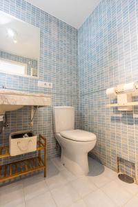 a bathroom with a toilet in a blue tiled wall at LUZ in Sierra Nevada
