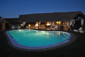 a swimming pool in front of a house at night at camera matrimoniale grande terrazza vista stupenda in Nosy Be