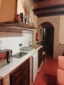 a kitchen with a sink and a stove top oven at CASA BACO in Casas Ibáñez