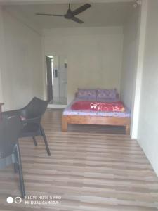 een slaapkamer met een bed en een stoel in een kamer bij Ha Lad in Mawlynnong