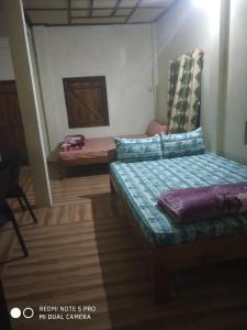 een kamer met een bed en een stoel. bij Ha Lad in Mawlynnong