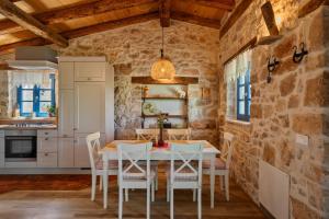 a kitchen with a table and chairs in a stone wall at Villa Paradiso in Umag