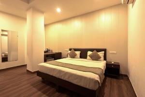 a bedroom with a large bed with two pillows at Luxury Tashree Hotel at Airport in New Delhi