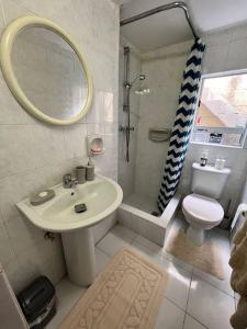 ein Badezimmer mit einem Waschbecken, einem WC und einem Spiegel in der Unterkunft Graswald, 1 bedroom accommodation in Gżira
