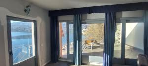 Habitación con puertas correderas de cristal y vistas al agua. en Lake view rooms and flats Casa Sul Lago en Orta San Giulio