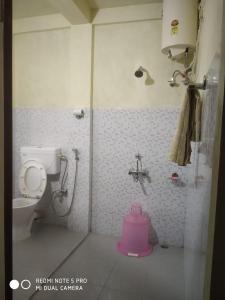 een badkamer met een roze toilet en een douche bij Ha Lad in Mawlynnong
