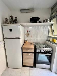 Il comprend une petite cuisine équipée d'une cuisinière et d'un réfrigérateur. dans l'établissement Graswald, 1 bedroom accommodation, à Il-Gżira