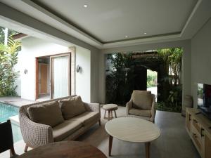 a living room with a couch and chairs and a table at Daun Lebar Villas in Payangan