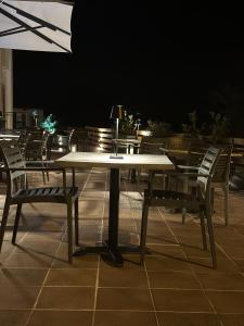 a table with chairs and an umbrella on a patio at Harma Corfu in Sidari