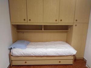 a small bed in a room with wooden cabinets at SKI AND OUTDOOR HOUSE in Frabosa Sottana