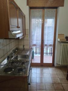 a kitchen with a stove and a door to a patio at SKI AND OUTDOOR HOUSE in Frabosa Sottana