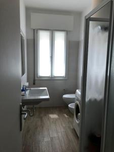 uma casa de banho com um lavatório, um WC e uma janela. em FAMILY APARTMENT VI20 - Piazza Brescia - Adria Holiday Jesolo em Lido di Jesolo