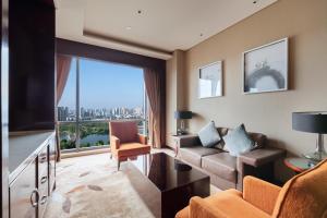 a living room with a couch and a large window at Sheraton Changde Wuling Hotel in Changde