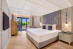 ein Hotelzimmer mit einem Bett und einem TV in der Unterkunft Antarim Resort in Candolim
