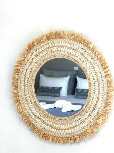 a mirror on a wall with a bed in a room at Harma Corfu in Sidari