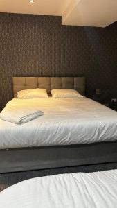 a large bed in a bedroom with white sheets at OYO The Pleasant House in Manchester