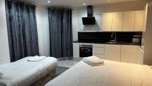 a bedroom with two beds and a kitchen with a tv at OYO The Pleasant House in Manchester
