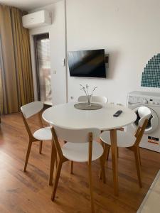 une salle à manger blanche avec une table et des chaises blanches dans l'établissement Neon Gondola apartment, à Bansko