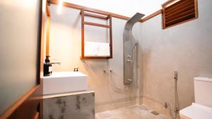 La salle de bains est pourvue d'un lavabo, de toilettes et d'une douche. dans l'établissement Daffodil Restaurant & Holiday Resort, à Unawatuna
