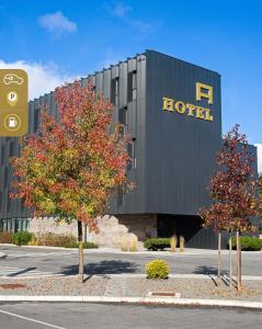 un hotel con alberi di fronte a un edificio di Hotel A a Celje