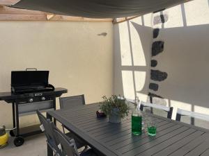 une table et des chaises avec une table et un grill dans l'établissement Gîte des Pierres de Barme, à Olby