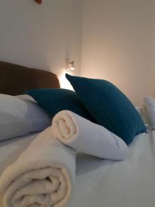 a towel on a bed with blue pillows at Hotel Wellness&Spa Astorya Banja Luka in Banja Luka