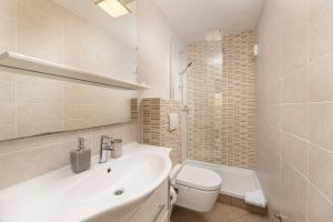 Baño blanco con lavabo y aseo en Apartments Lacrima en Šilo