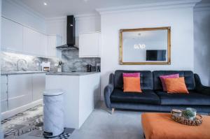 Caldey View - Luxury 2 Bedroom - Panorama - Tenby في تينبي: غرفة معيشة مع أريكة ومطبخ