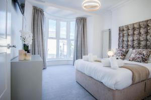 een slaapkamer met een groot bed en een groot raam bij Caldey View - Luxury 2 Bedroom - Panorama - Tenby in Tenby