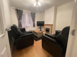 un soggiorno con 2 sedie e una TV di Homely and very comfortable apartment a Londra