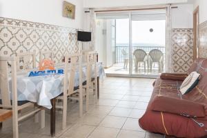 a dining room with a table and chairs and a balcony at Santa Marta, I- A 4º-11 in Cullera