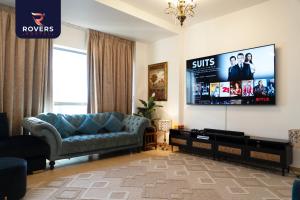 a living room with a couch and a flat screen tv at Rovers Hostel Dubai in Dubai