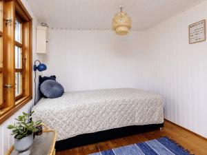 een slaapkamer met een bed in een witte kamer bij Holiday home Væggerløse XL in Bøtø By