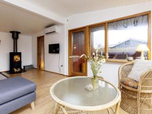 een woonkamer met een salontafel en een open haard bij Holiday home Væggerløse XL in Bøtø By