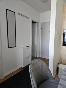 a living room with a chair and a mirror at Apartman FITT in Zagreb