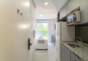 a kitchen with a sink and a door to a room at Easy Star - Lindo Studio próx.Metrô Ana Rosa - LN02H in Sao Paulo