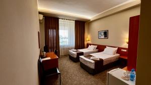 Olympia Garden Hotel في يريفان: غرفة فندقية بسريرين واريكة