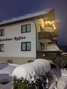 a building with snow on the ground in front of it at Gästehaus Regina in Ruhla