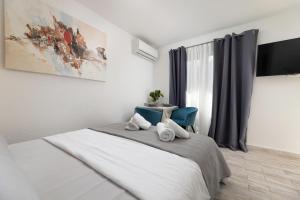 1 dormitorio con 1 cama con toallas en Apartments Lacrima en Šilo