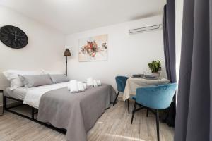 1 dormitorio con cama, mesa y reloj en Apartments Lacrima, en Šilo 54 fotos más