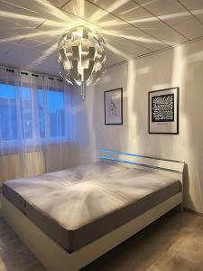 a bedroom with a large bed and a chandelier at Zimmer in 100m² Wohnung mit Terrasse in Duisburg