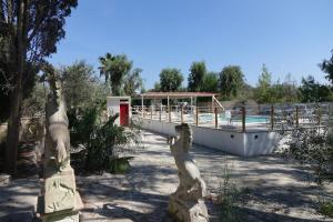 a statue of lions next to a swimming pool at Giardini Sausari Residence in Punta Prosciutto