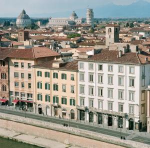 a large white building next to a city at Royal Victoria Hotel in Pisa