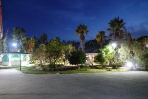 a parking lot with palm trees and a building at Giardini Sausari Residence in Punta Prosciutto