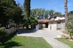 a house with a driveway in a yard at Giardini Sausari Residence in Punta Prosciutto