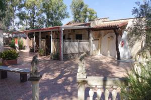 a house with a porch and a bench in front of it at Giardini Sausari Residence in Punta Prosciutto