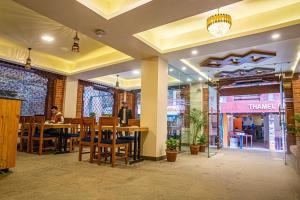 restauracja ze stołem, krzesłami i osobą w obiekcie Darbar Heritage Inn w Katmandu