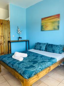 uma cama num quarto com uma parede azul em Casa Cinza em Ponta do Ouro