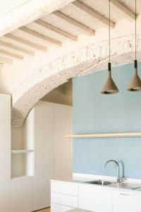 a kitchen with white cabinets and two lights at La Calata - Monolocale in Portoferraio