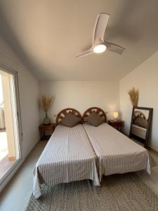 a bedroom with a bed with a ceiling fan at SA CALMA - Duplex con piscina y cerca del Mar - Deltavacaciones in L'Ampolla +26 photos